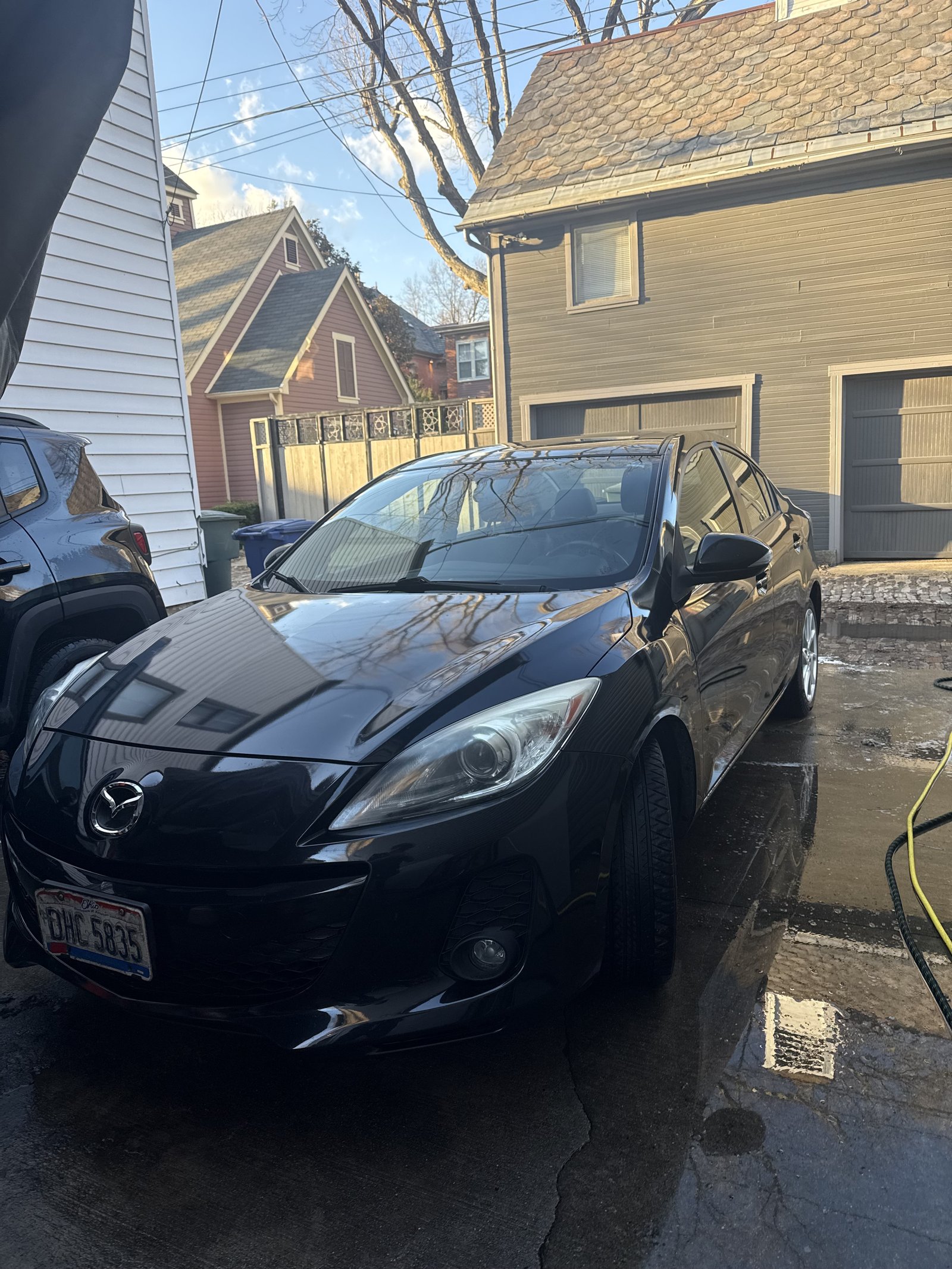 Black Mazda 3 front three-quarter view after detailing